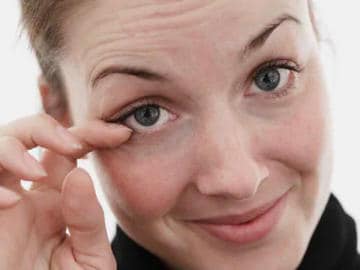 Frau kratzt sich am Auge
