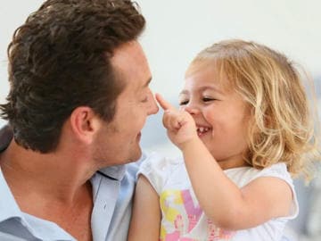 Que faire en cas de sécheresse nasale ? Un enfant caresse le nez de son père.